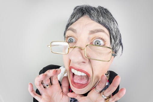 A funny fisheye image of an older woman terrified and screaming.