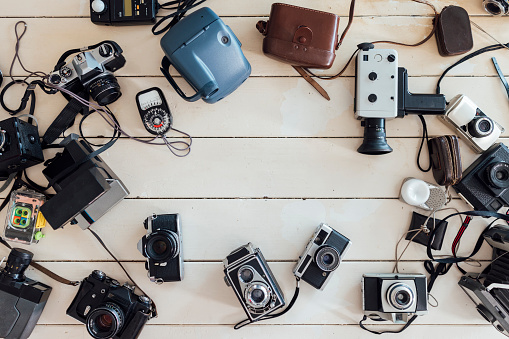 A directly above view of a range of new and old cameras on a wooden table in a room in Horsley, Northumberland.