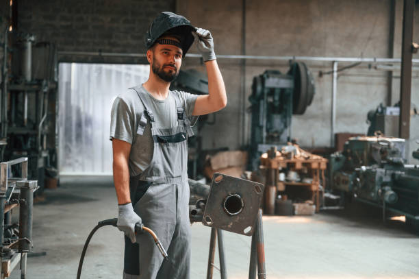 istock Taking a break. With welding equipment. Young factory worker in grey uniform 1822657807
