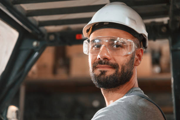 istock In the forklift. Young factory worker in grey uniform 1822662692
