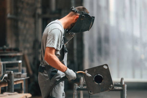 istock Process of welding. Young factory worker in grey uniform 1822675974
