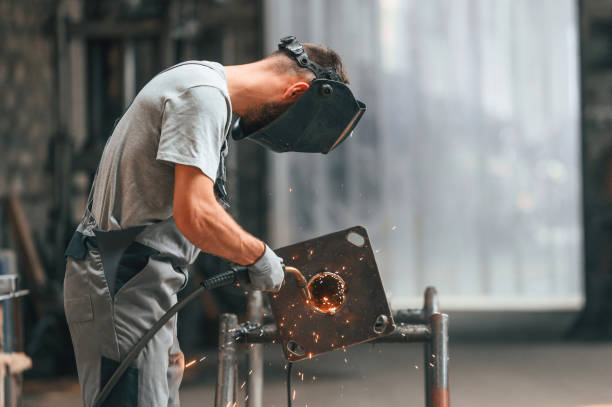 istock Process of welding. Young factory worker in grey uniform 1822675980