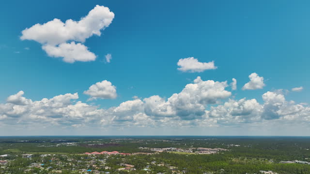 Aerial landscape view of suburban private houses in Florida quiet rural area. Blue sky with white clouds over suburbs