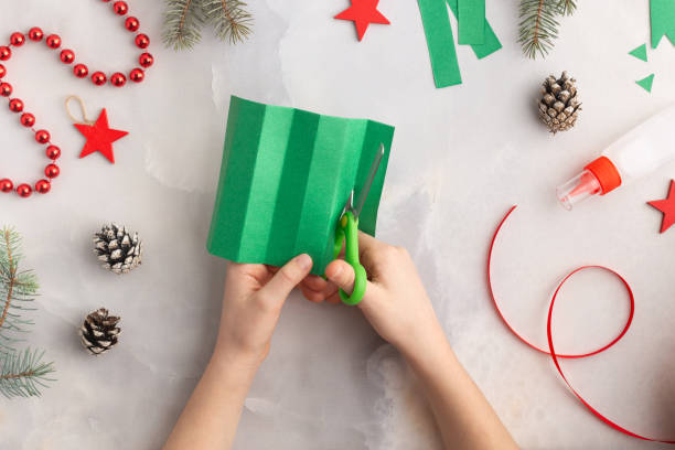 istock Christmas wreath from color paper with children. Step by step instructions. Handmade DIY new year holiday decoration project. 1822697152