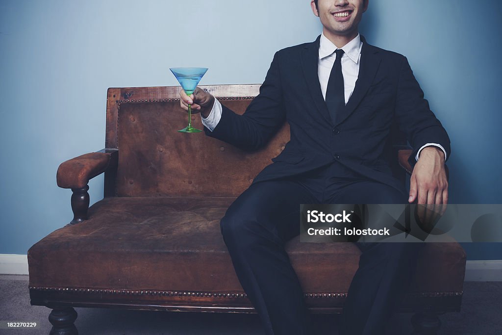 Feliz hombre de negocios en el sofá bebiendo cócteles - Foto de stock de Beber libre de derechos