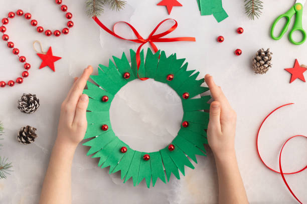Christmas wreath from color paper with children. Step by step instructions. Handmade DIY new year holiday decoration project. stock photo