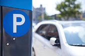 A blue parking ticket machine beside the road 