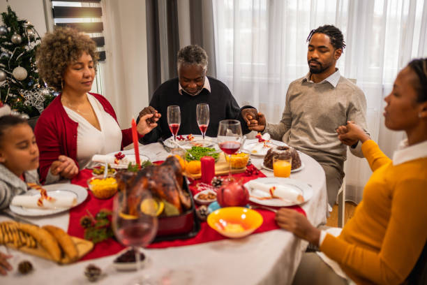 istock Family praying before eating delicious Christmas dinner. 1822740387