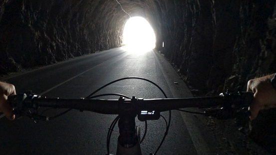 POV of electric-mountain biker riding through tunnel