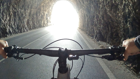 POV of electric-mountain biker riding through tunnel