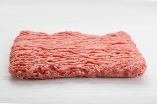 Raw fresh minced meat on white wooden table, closeup
