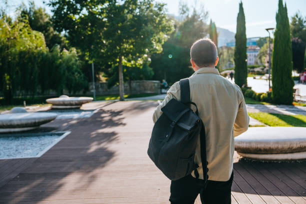 istock Rear view of walking young man with backpack exploring new city after relocation. Purposeful freelancer goes to work at office. Traveler walking at park  at southern city.
Trip, journey. 1822756207