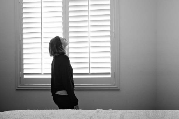 istock Woman standing by window 1822765707