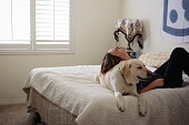 Woman laying on bed with her dog