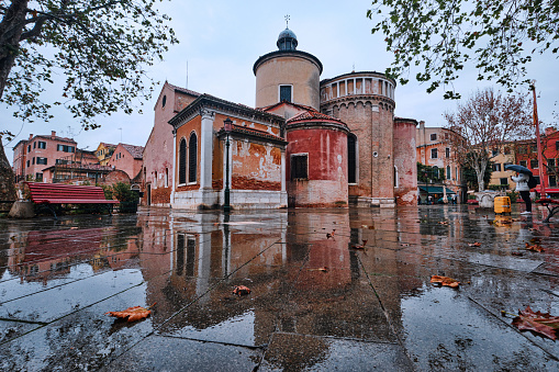 Venice, Italy - November 9 2023: View on the church of San Giacomo dall Orio and reflection of it on a rainy day