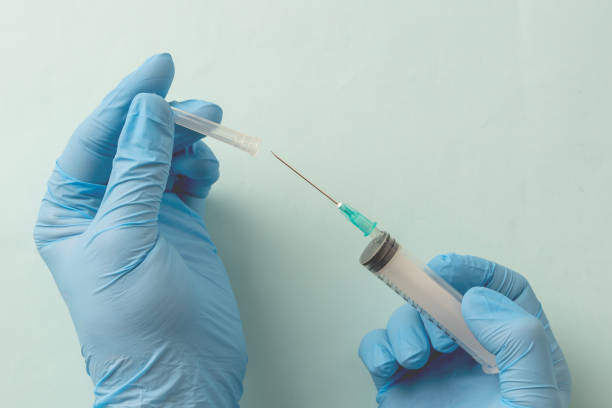 istock Doctor is holding a syringe , isolated on blue background 1822768541