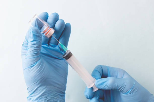 istock Doctor is holding a syringe , isolated on blue background 1822768545