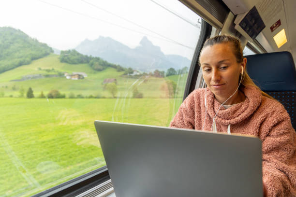 istock Young woman working on a laptop while traveling by train 1822772467