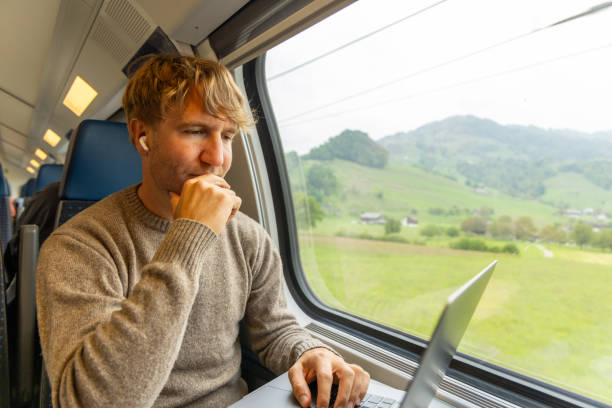 istock Young man working on a laptop while traveling by train 1822773546