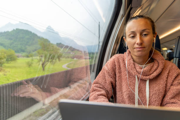 istock Young woman working on a laptop while traveling by train 1822773547