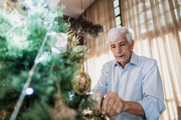 istock Senior man decorating the christmas tree at home 1822774637