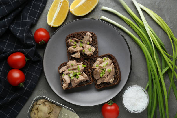 istock Tasty sandwiches with cod liver and different products on light grey table, flat lay 1822776835