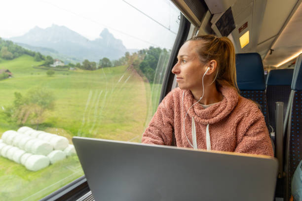 istock Young woman working on a laptop while traveling by train 1822778599