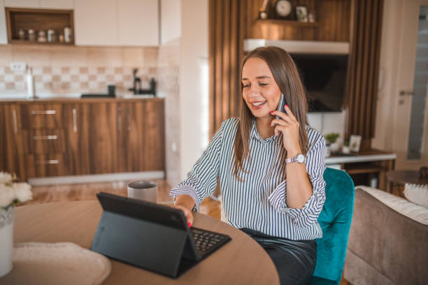 istock Beautiful business woman having a phone call while working remotely using a digital tablet 1822783541