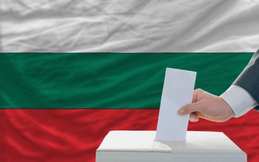 man putting ballot in a box during elections in bulgaria