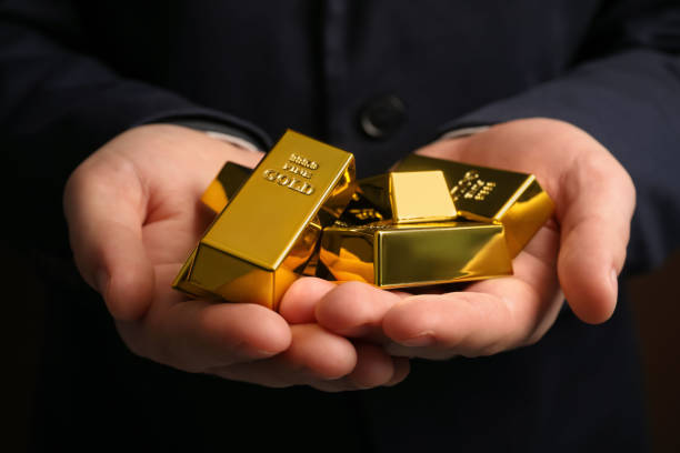 istock Man holding many shiny gold bars, closeup 1822822709