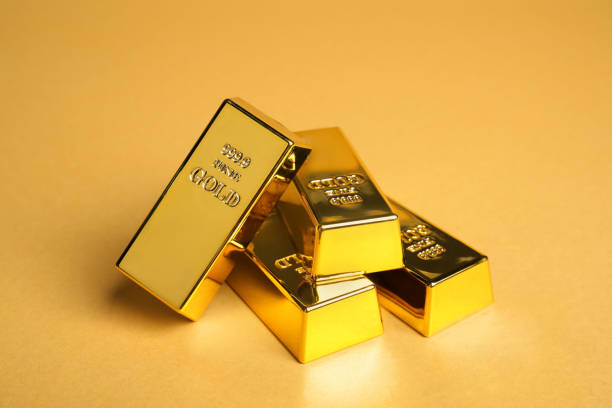 istock Many shiny gold bars on pale orange background 1822825555