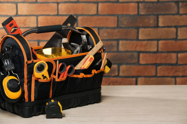 istock Bag with different tools for repair on white wooden table near brick wall. Space for text 1822836253