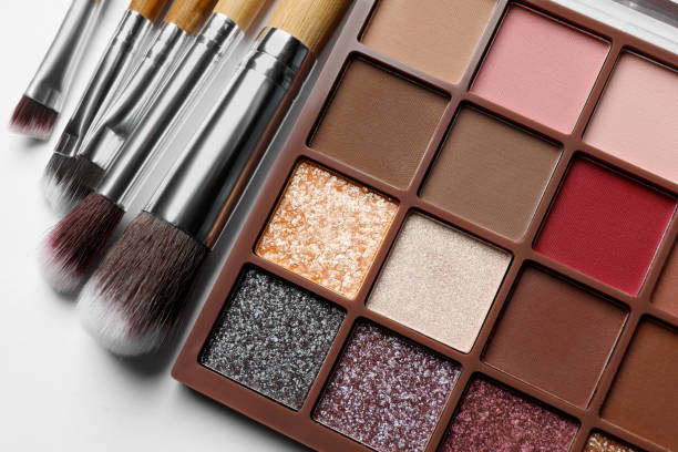istock Beautiful eye shadow palette and brushes on white table, flat lay 1822837277