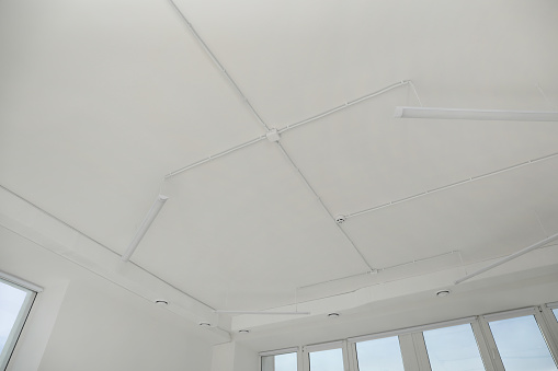 White ceiling with modern lighting in office