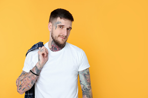 Portrait of handsome hipster man on yellow background. Space for text