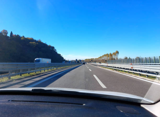 wide free highway with car dashboard in the foreground during a road trip