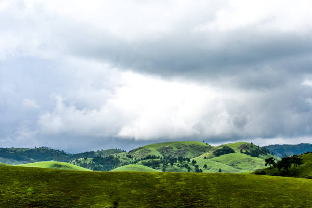 istock Hills covered in grass and clouds above. 1822928315