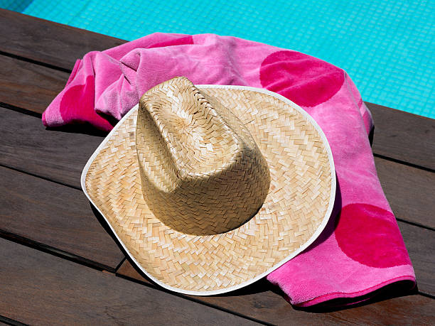 istock Sun hat and beach towel by swimming pool 182293282