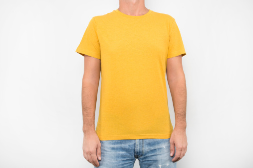 Male standing on white with yellow t-shirt on, hands are on his sides.