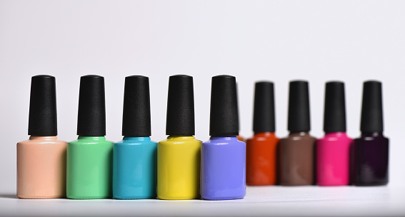Colourful nail polishes bottles, close up.