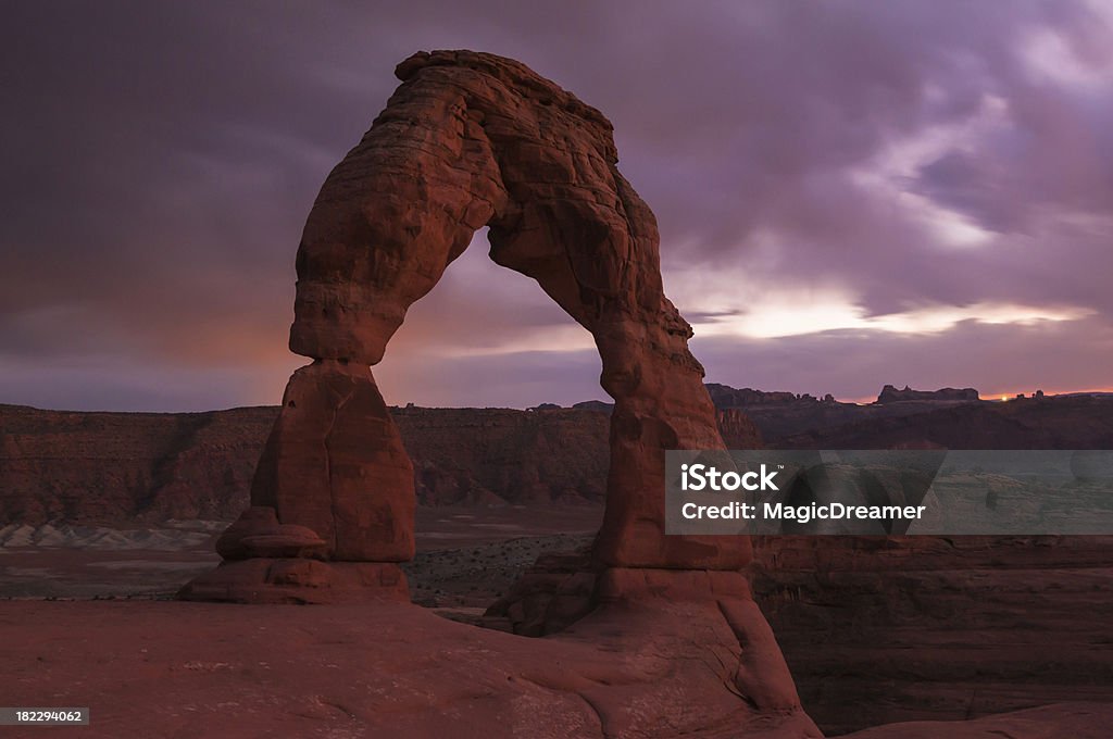 Delicate Arch o zachodzie słońca - Zbiór zdjęć royalty-free (Chmura)