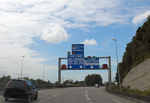large road sign with French locations to reach port Le Havre Port or Normandy bridge to cross the Seine river in Northern France