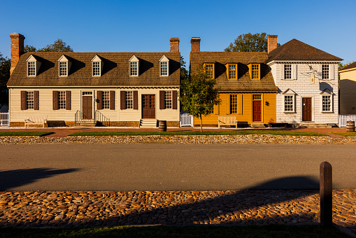 Colonial row houses on a sunny paving stone street in Colonial Williamsburg, Virginia