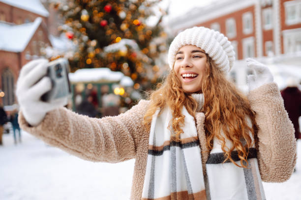 istock Young tourist uses a smartphone while walking through a Christmas market. 1822980728