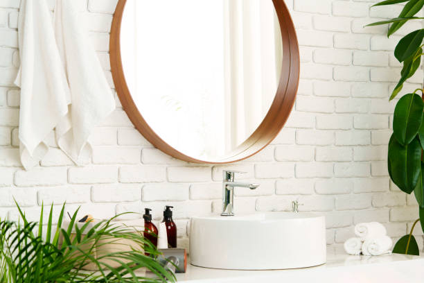 istock Bathroom interior with circle shaped mirror in wooden frame and white sink 1822984456