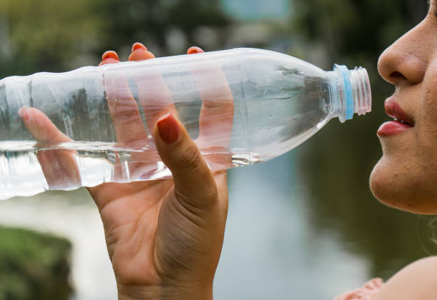 istock close-up of a woman's lips drinking water while holding a bottle of water. 1822993992