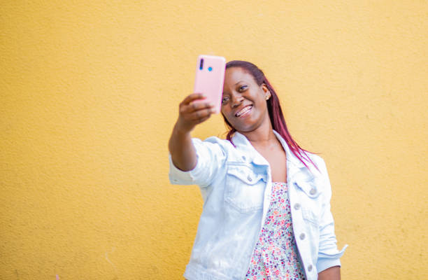 istock cute woman smiling while taking a selfie with her mobile phone 1822997755
