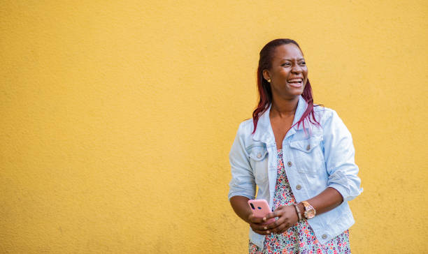 istock young woman using her mobile phone while looking to the side on a yellow background 1823005798