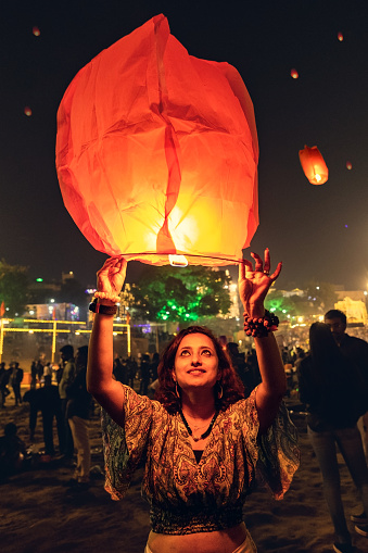 VARANASI, UTTAR PRADESH, INDIA -2023_11_26: People are considering good luck to release a sky lantern and also believing symbolic of problems and worries floating away during Dev Dipawali. Dev Deepavali, also known as Diwali of the Gods, is a festival celebrated on Karthik Purnima, which falls 15 days after Diwali. Dev Deepavali is the biggest Light Festival in India, where devotees decorate the river bank of the Ganges with millions of Lamps as part of the festival.