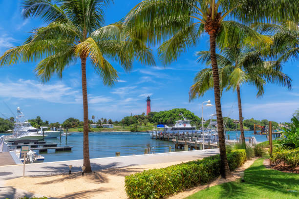 Jupiter lighthouse and harbor at sunny summer day and palm trees, West Palm Beach, Florida.